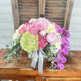 Pink and white floral arrangement with orchids and hydrangeas in a vase