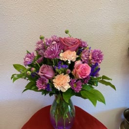 Pink and purple mixed bouquet in a clear glass vase