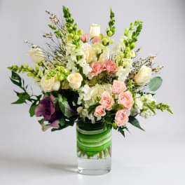 Mixed bouquet of roses and snapdragons in a clear glass vase