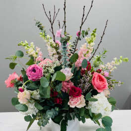 Mixed pink and white floral arrangement in a white vase