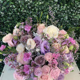 Pastel bouquet of roses and lisianthus with small purple filler flowers