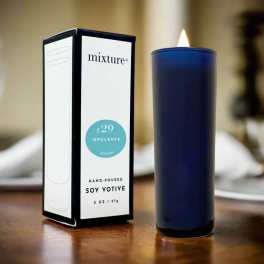 Blue votive candle beside its box on a table