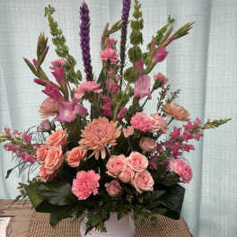 Pink and peach floral arrangement in a white vase