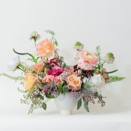 Mixed pastel flower arrangement in a white vase
