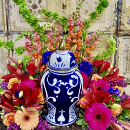 Colorful floral arrangement around a blue-and-white ceramic urn