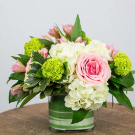 Pink roses and white hydrangeas in a green-striped vase