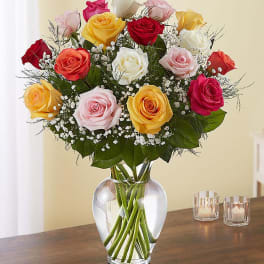 Mixed roses in a clear glass vase with baby's breath