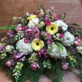 Large mixed floral arrangement with white hydrangeas, pink roses, and yellow gerbera daisies