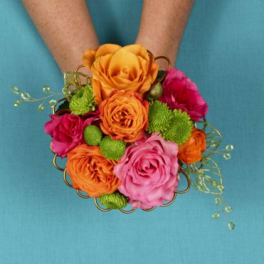 Handheld bouquet of orange, pink, and green flowers
