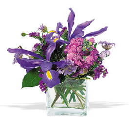 Purple and pink mixed bouquet in a clear glass vase