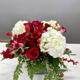 Red roses and white hydrangeas in a low rectangular vase