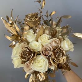 Bouquet of cream and gold roses with metallic foliage