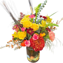 Colorful bouquet of yellow roses, red mums, and pink carnations in a painted vase