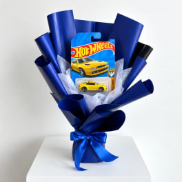 Hot Wheels toy car gift bouquet wrapped in blue paper with a ribbon
