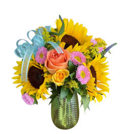 Sunflower and rose bouquet in a green glass vase with blue ribbon