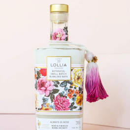 Floral-patterned bath bottle with a pink tassel and gold cap