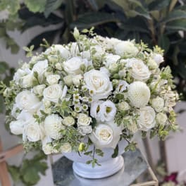 White rose and dahlia arrangement in a white vase