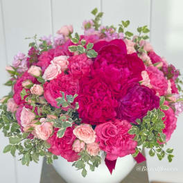Pink and magenta rose bouquet in a white vase