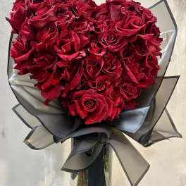 Bouquet of red roses wrapped in black paper with a ribbon