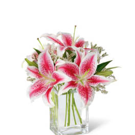 Pink and white lilies in a clear glass vase