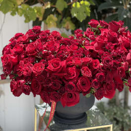 Large arrangement of red roses in a dark vase