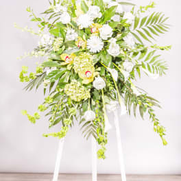 Tall white floral standing spray on a white easel