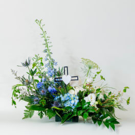 Blue and white floral arrangement with a cross centerpiece