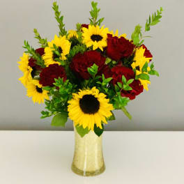Bouquet of red roses and yellow sunflowers in a gold vase