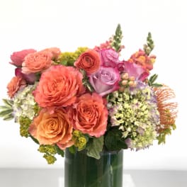 Colorful bouquet of roses and mixed blooms in a glass vase