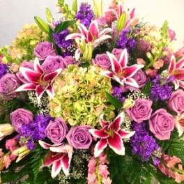 Large bouquet of purple roses and pink lilies with mixed blooms
