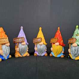 Five colorful gnome figurines holding welcome signs