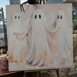 Canvas with three cartoon ghosts on an easel