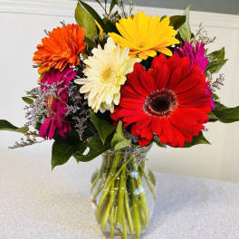 Colorful gerbera daisy bouquet in a clear glass vase