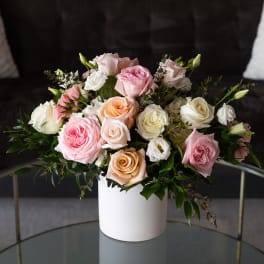 Bouquet of pastel roses in a white cylindrical vase