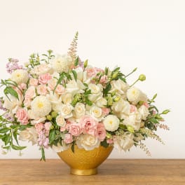Blush and white rose arrangement in a gold bowl vase