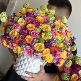 Large bouquet of multicolored roses in a white textured vase