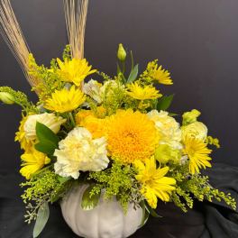 Yellow and white floral arrangement in a white pumpkin-shaped vase