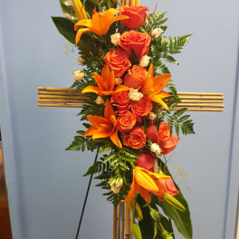 Tall floral standing spray with orange roses and lilies on a bamboo easel