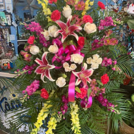 Large standing floral spray with pink lilies, white roses, and yellow blooms