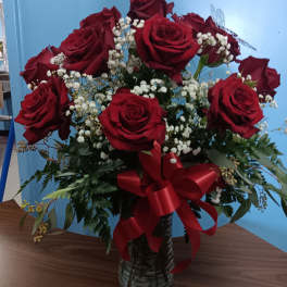 Bouquet of red roses with white baby's breath in a glass vase