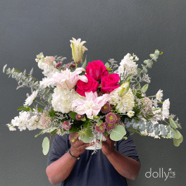 Large bouquet of pink roses, white lilies, and white blooms in a vase