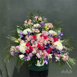 Large mixed bouquet in a white container with pink and purple flowers