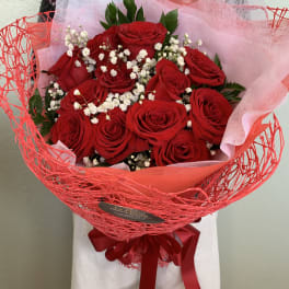 Bouquet of red roses with white baby's breath in red wrap