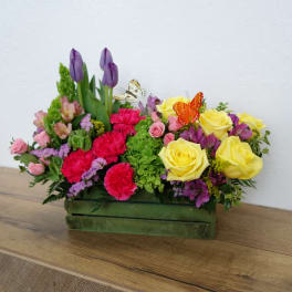 Mixed bouquet in a green rectangular box with yellow roses and purple tulips