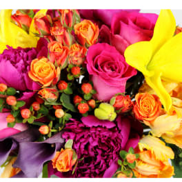 Bright mixed bouquet with pink roses, orange spray roses, and yellow lilies