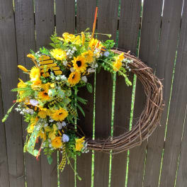Yellow floral wreath on a grapevine ring with bee decorations