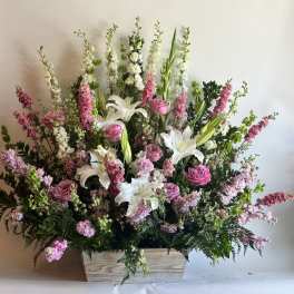 Large pink and white floral arrangement in a wooden box