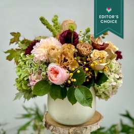 Mixed bouquet in a white vase with pink, cream, and burgundy blooms