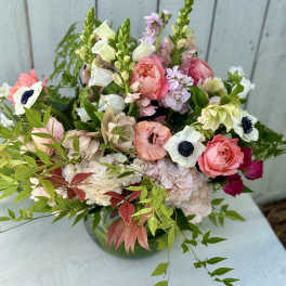 Mixed pink and white bouquet with anemones and roses in a vase