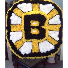 Large floral tribute shaped like a black and gold letter B